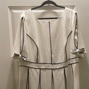 Party dress with princess seams, trim waist and flared godets. Bows at sleeves.